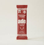 Red and white electrolyte drink mix package for tropical punch on a beige background, bundle-selector